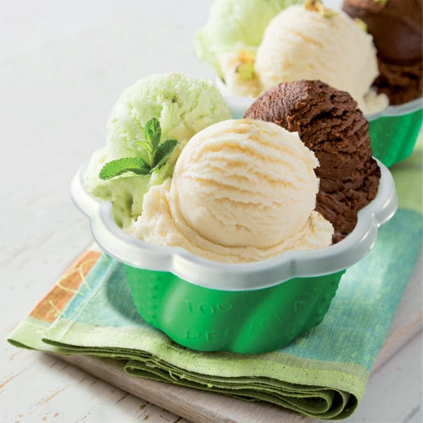 Three scoops of ice cream in a green bowl on a cloth.