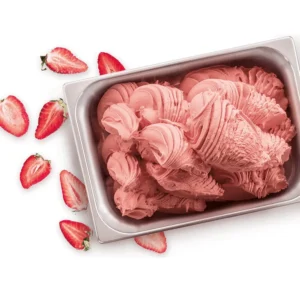 A stainless steel container filled with swirled Elenka Fruit Bases strawberry Gelato is surrounded by sliced strawberries on a white background.