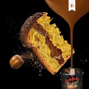 A slice of golden panettone with a rich chocolate filling is topped with chocolate sprinkles. Next to it is a scoop of chocolate hazelnut spread, with a decorative gold drip and a branded container below.