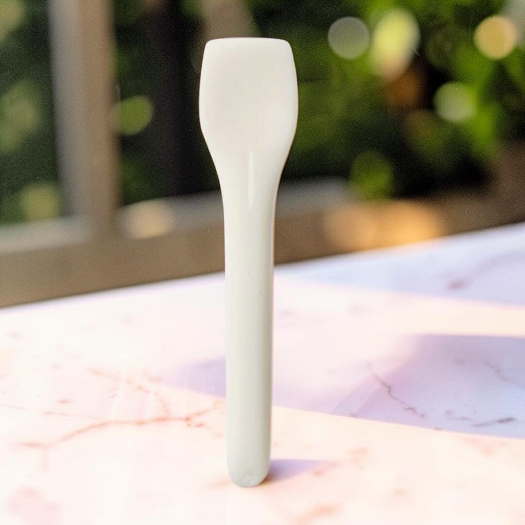 Alcas compostable PLA gelato spoon cream PA088012010 on cafe table