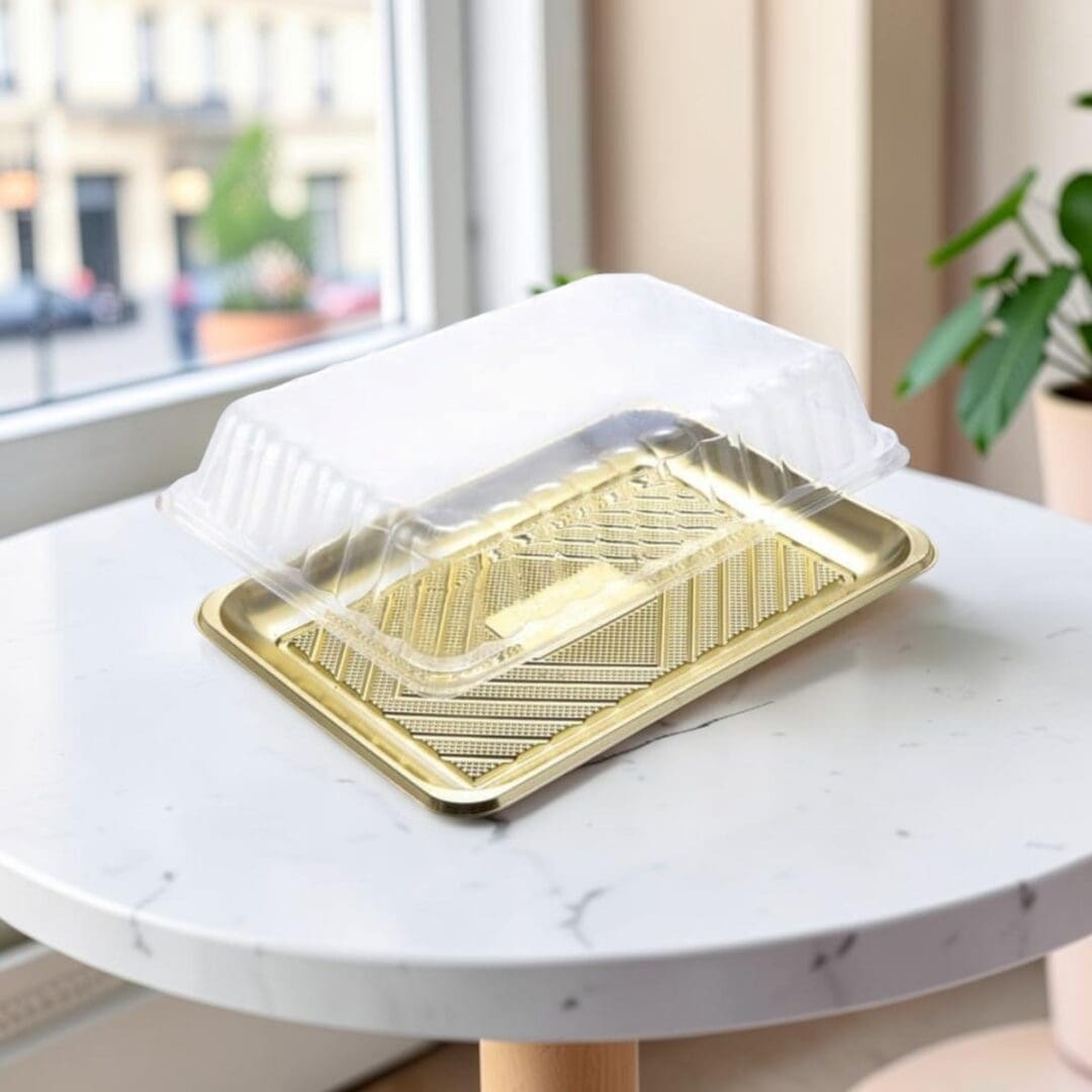 Alcas Kado gold pastry tray with clear lid on patisserie cafe table